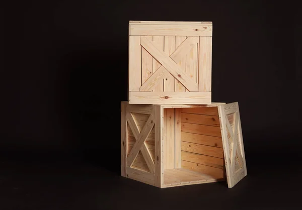 Wooden crates on black background. Space for text