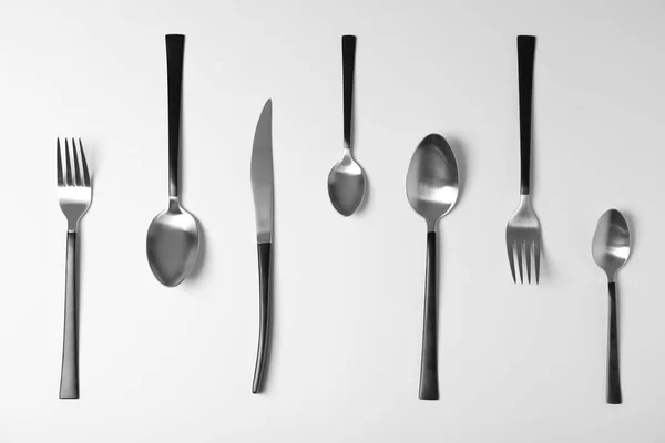 Set of new metal cutlery on white background, top view — Stock Photo, Image