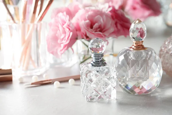 Frascos de perfume diferentes na mesa de vestir, espaço para texto — Fotografia de Stock