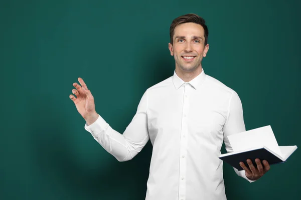 Retrato de maestro masculino con libro sobre fondo de color — Foto de Stock