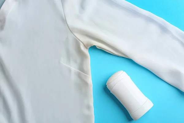 Kleding met vlek en deodorant op licht blauwe achtergrond, bovenaanzicht — Stockfoto