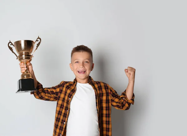 Gelukkige jongen met gouden winnende Cup op witte achtergrond — Stockfoto