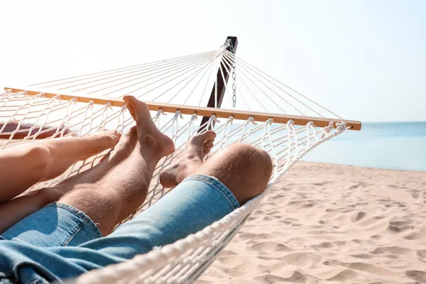 Coppia giovane che si rilassa in amaca sulla spiaggia, primo piano — Foto Stock