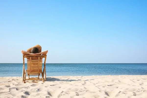 砂浜のデッキチェアでリラックスした若い女性 — ストック写真