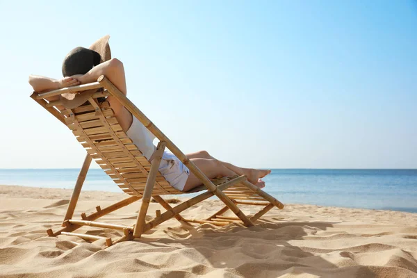 年轻女子在沙滩上的躺椅上放松 — 图库照片