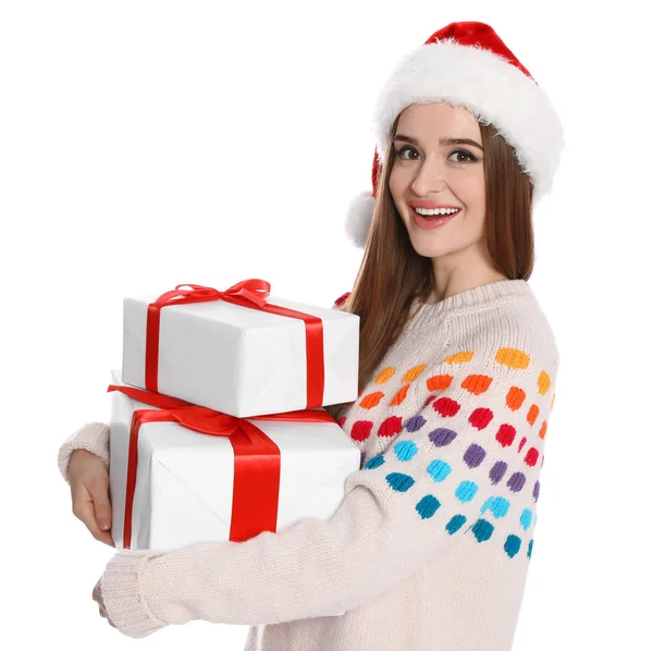 サンタの帽子と白い背景にギフトボックスとセーターで幸せな若い女性。クリスマスのお祝い — ストック写真