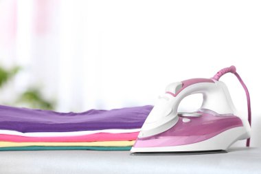 Modern elektrikli demir ve odada gemide temiz katlanmış giysiler. Metin için alan