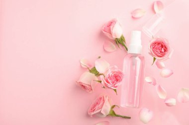 Pembe arka plan üzerinde gül uçucu yağ ve çiçekler ile Düz yatıyordu kompozisyon, metin için alan