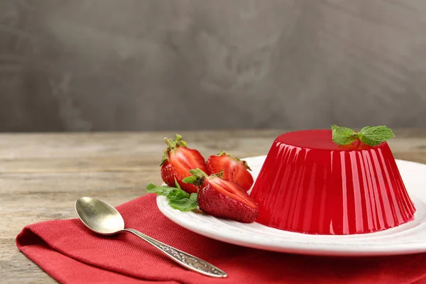 Assiette de savoureuse gelée de fraises servie sur table en bois, espace pour le texte — Photo