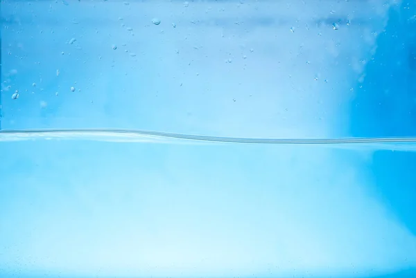 Чистая пресная вода волна на синем фоне — стоковое фото
