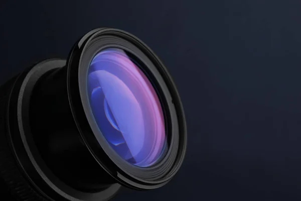 Lente de câmera profissional no fundo azul escuro, close-up. Espaço para texto — Fotografia de Stock