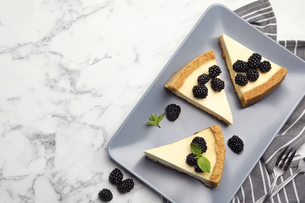 Pedaços de delicioso cheesecake com amoras no fundo de mármore branco, flat lay. Espaço para texto — Fotografia de Stock