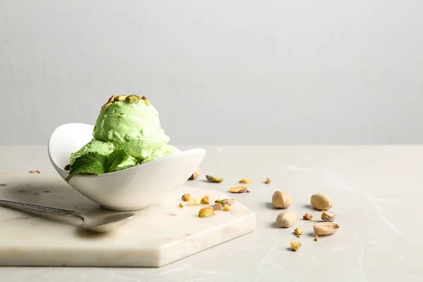 Chutné pistáciové zmrzliny podávané na šedém stole proti světelným pozadím, prostor pro text — Stock fotografie