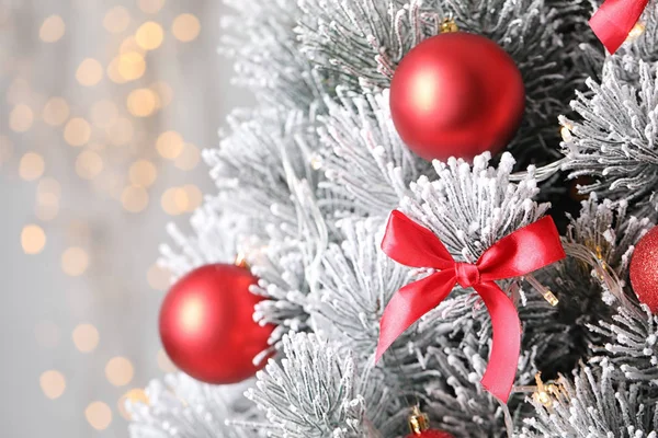 Schöner Weihnachtsbaum mit Dekor gegen verschwommenes Licht auf dem Hintergrund — Stockfoto