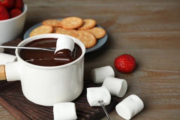 Fonduetopf mit Schokolade und Eibisch auf Holztisch — Stockfoto