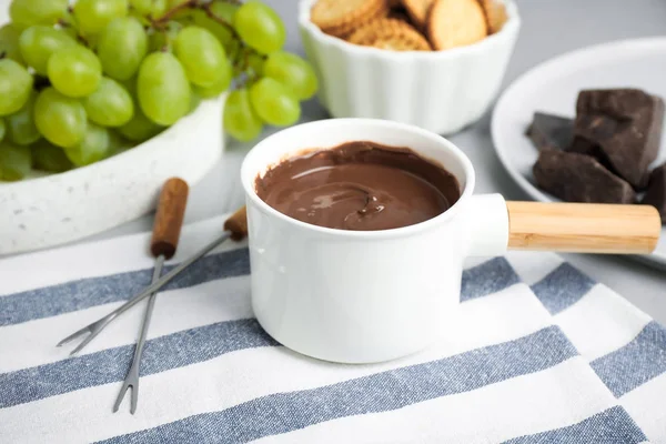 Fonduetopf mit Schokolade und Trauben auf dem Tisch — Stockfoto