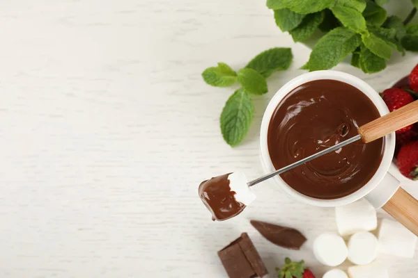 Flache Liegekomposition mit Fonduetopf und Schokolade auf weißem Holztisch, Platz für Text — Stockfoto