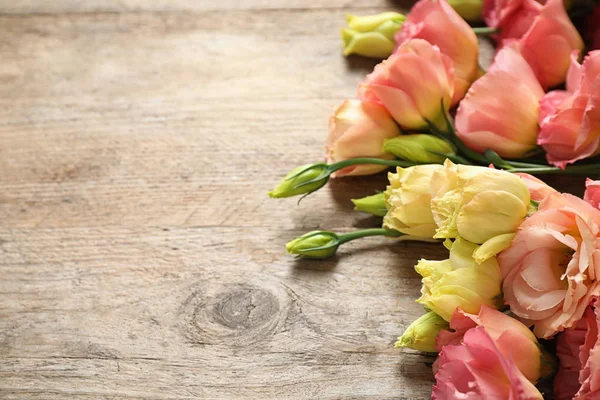 Lindas flores frescas Eustoma na mesa de madeira, espaço para texto — Fotografia de Stock