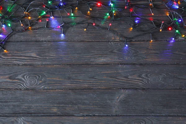 Weihnachtsbeleuchtung auf Holzhintergrund, Draufsicht. Raum für Text — Stockfoto