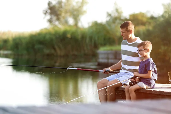 Pai e filho pesca juntos no dia ensolarado — Fotografia de Stock