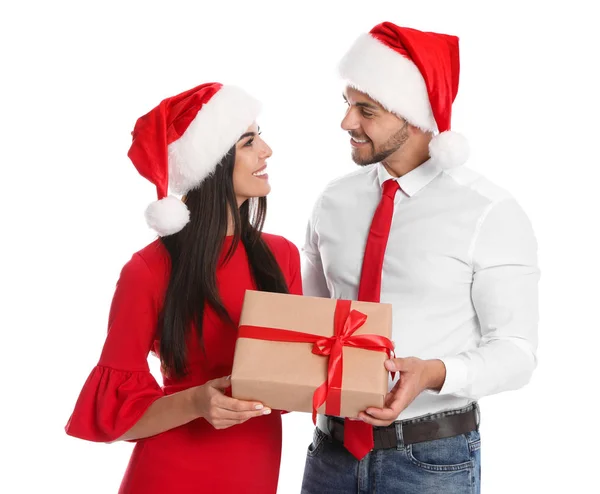 Encantador jovem casal em chapéus de Papai Noel com caixa de presente no fundo branco. Celebração de Natal — Fotografia de Stock