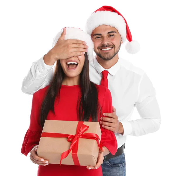 可爱的年轻夫妇在圣诞老人的帽子与白色背景的礼物盒。圣诞节庆祝活动 — 图库照片