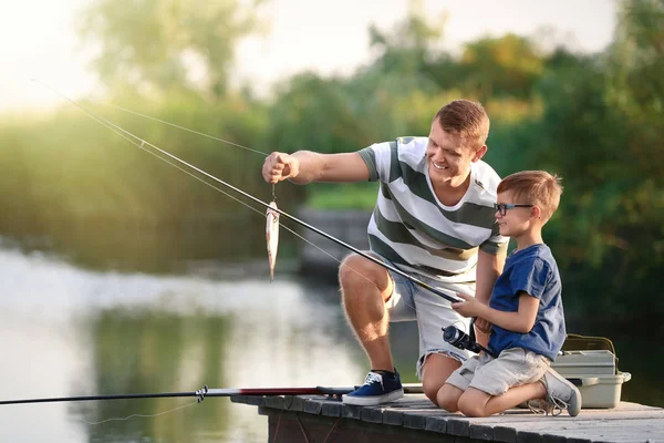 Pai e filho pesca juntos no dia ensolarado — Fotografia de Stock