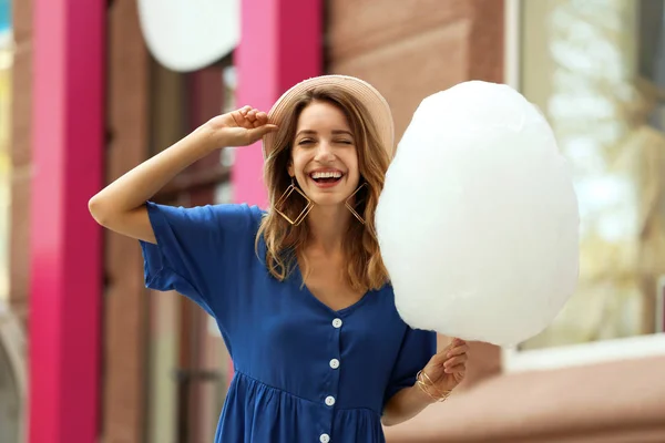 Mujer joven feliz con algodón de azúcar al aire libre — Foto de Stock