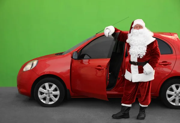Autêntico Papai Noel perto de carro contra fundo verde — Fotografia de Stock