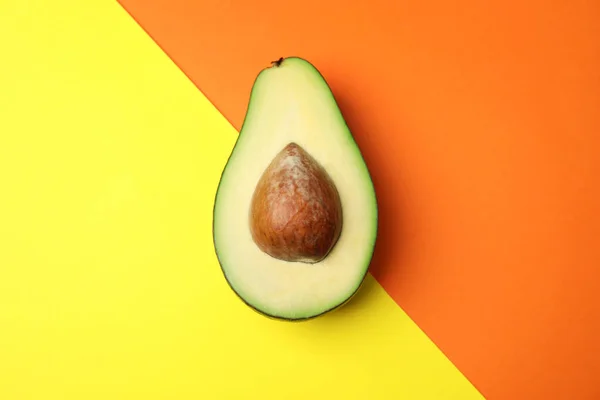 Geschnitten frische reife Avocado auf farbigem Hintergrund, Draufsicht — Stockfoto