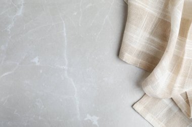 Açık mermer arka plan üzerinde Bej ekose mutfak havlusu, üst görünümü. Metin için alan