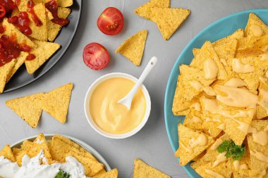 Gri masada farklı soslar ile Meksika nacho cips, düz yatıyordu