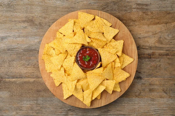 Board with Mexican nacho chips and sauce on wooden background, top view — Stock Photo, Image