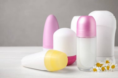 Beyaz masa üzerinde doğal kadın roll-on deodorantlar ve papatya çiçekleri