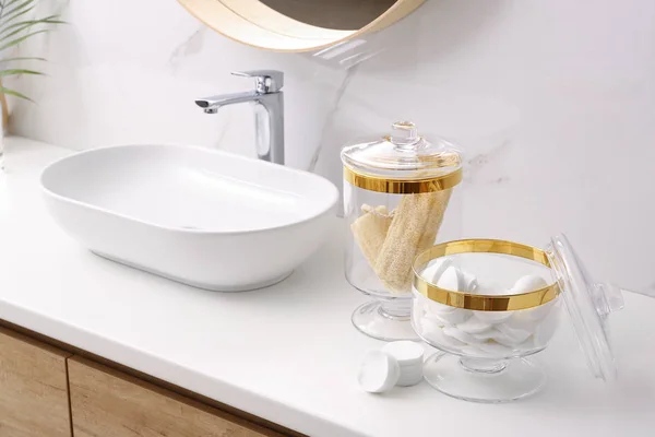 Üvegedények pamut párna és loofahs az asztalon a fürdőszobában — Stock Fotó