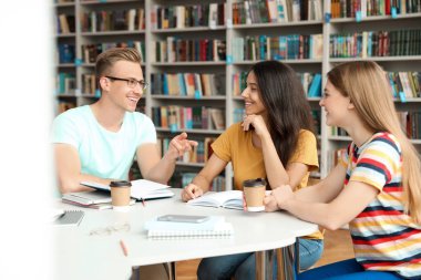 Gençler kütüphanede grup projesini tartışıyorlar