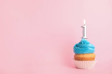 Pembe arka plan üzerinde bir numaralı mum ile Doğum günü cupcake, metin için alan