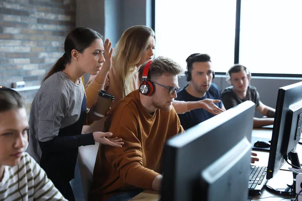 Grupo de personas que juegan videojuegos en el cibercafé —  Fotos de Stock