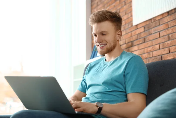 Hombre joven usando el ordenador portátil en la sala de estar — Foto de Stock