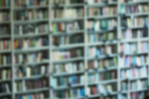 Vista borrosa de los estantes con libros en la biblioteca — Foto de Stock