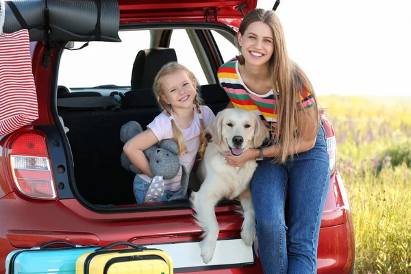 Mère et fille heureuses avec leur chien dans le coffre de la voiture à l'extérieur — Photo