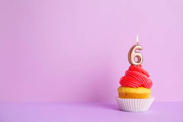 Cupcake d'anniversaire avec numéro six bougie sur fond violet, espace pour le texte — Photo