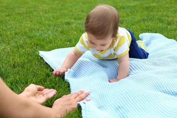Sevimli küçük bebek battaniye açık havada annedoğru sürünen — Stok fotoğraf