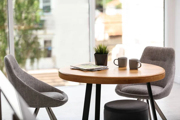라운드 테이블과 편안한 의자가있는 세련된 객실 인테리어 — 스톡 사진