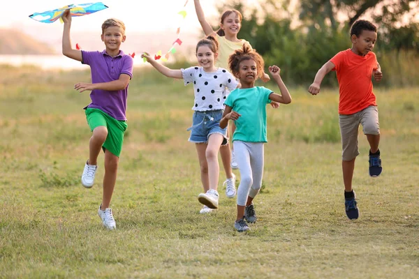 Niedliche kleine Kinder spielen mit Drachen im Freien — Stockfoto