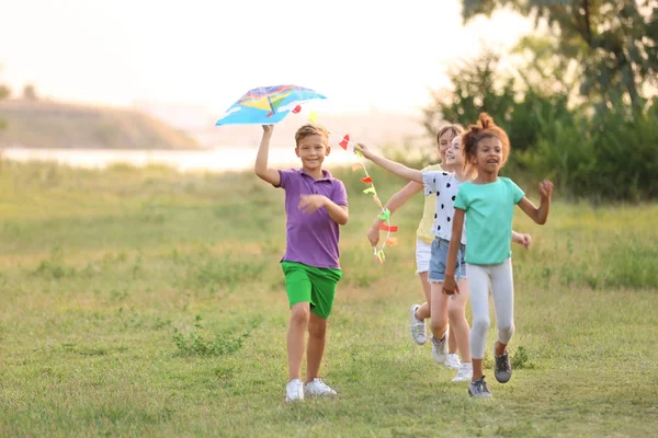 Lindos niños pequeños jugando con cometa al aire libre —  Fotos de Stock