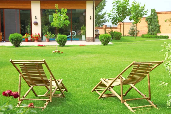 Wooden deck chairs in beautiful garden on sunny day — Stock Photo, Image