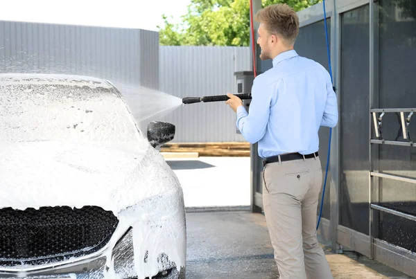 셀프 서비스 세차장에서 고압 워터 제트로 자동차를 청소하는 사업가 — 스톡 사진