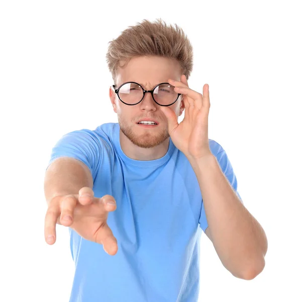 Young man with vision problem wearing glasses on white background Stock Picture