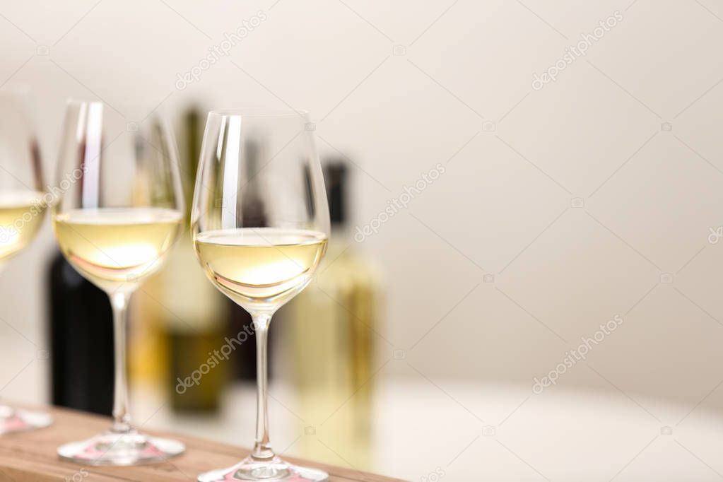 Glasses of wine on wooden board, space for text